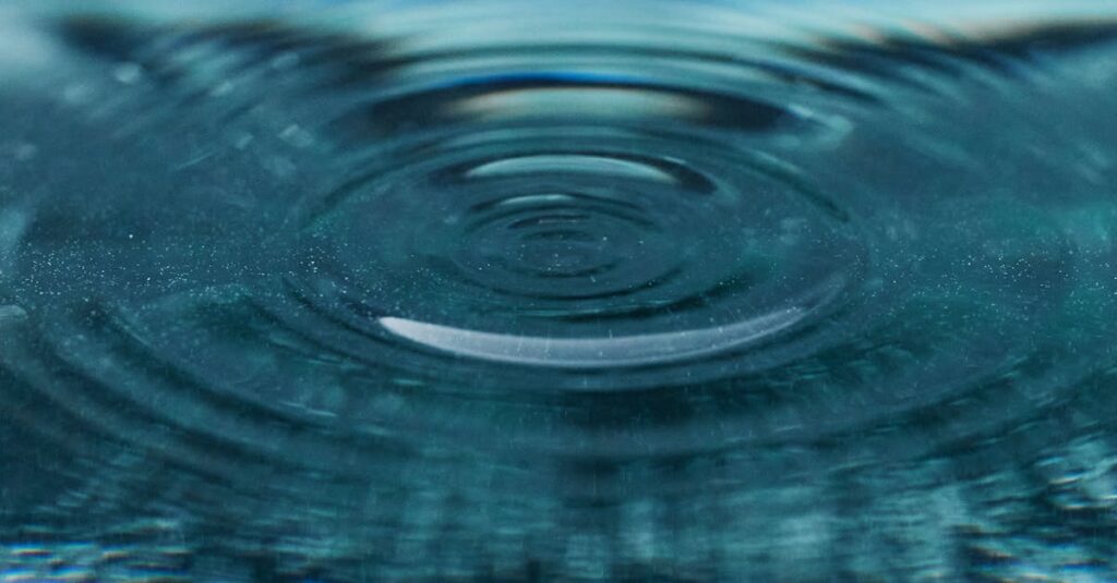Beautiful detailed view of a ripple expanding on a blue water surface, capturing texture and motion.